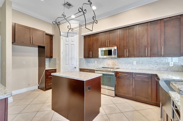 kitchen with light stone counters, ornamental molding, appliances with stainless steel finishes, and backsplash