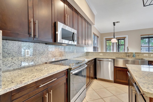 kitchen featuring sink, light tile patterned floors, stainless steel appliances, decorative backsplash, and decorative light fixtures