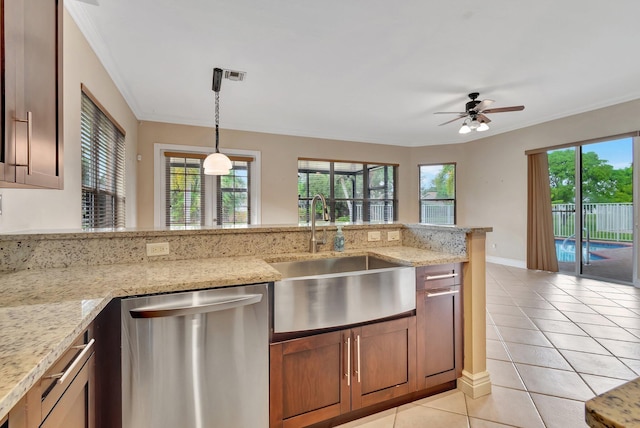 kitchen with sink, hanging light fixtures, light tile patterned floors, dishwasher, and light stone countertops