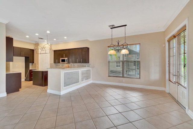 kitchen with light tile patterned floors, dark brown cabinets, ornamental molding, and light stone countertops