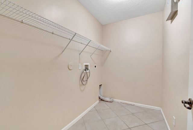 laundry room with washer hookup, a textured ceiling, light tile patterned flooring, hookup for a gas dryer, and hookup for an electric dryer