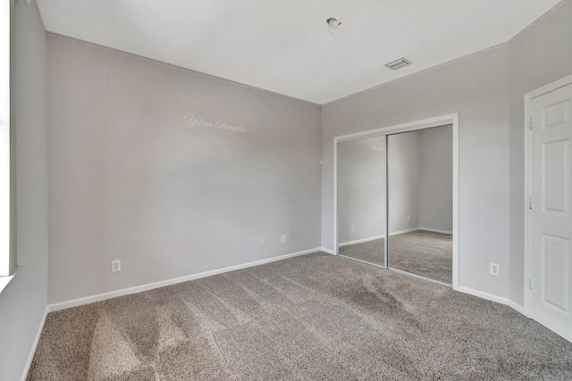 unfurnished bedroom with carpet and a closet