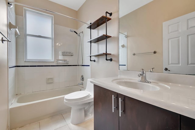 full bathroom featuring tile patterned flooring, vanity, tiled shower / bath, and toilet