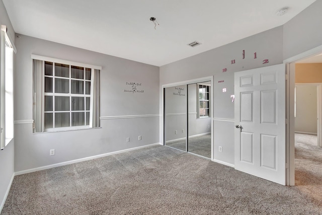 unfurnished bedroom with carpet floors and a closet