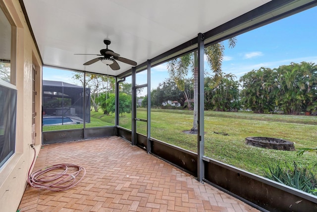 unfurnished sunroom with ceiling fan