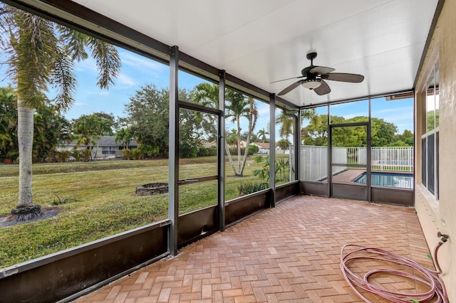 unfurnished sunroom featuring ceiling fan