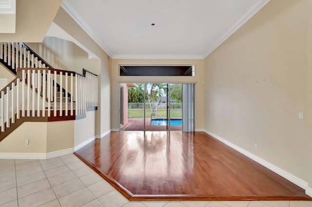 foyer with crown molding and light tile patterned floors