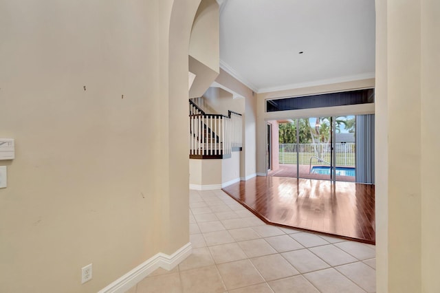 tiled foyer entrance featuring crown molding