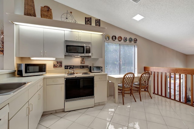 kitchen with vaulted ceiling, light tile patterned flooring, sink, white electric range oven, and a textured ceiling