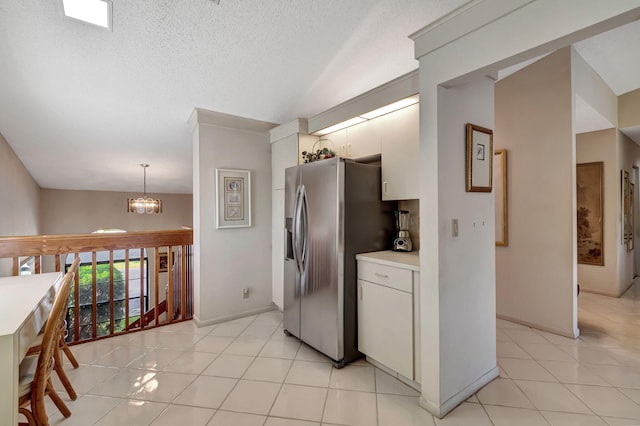 kitchen with decorative light fixtures, white cabinets, light tile patterned floors, stainless steel refrigerator with ice dispenser, and an inviting chandelier