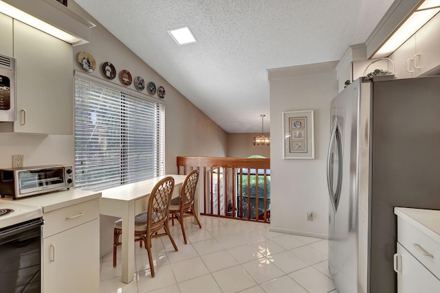 kitchen featuring stainless steel fridge, hanging light fixtures, light tile patterned floors, a notable chandelier, and a textured ceiling