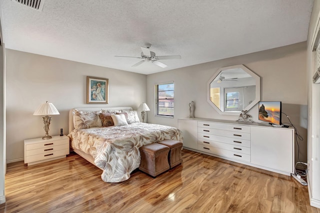 bedroom featuring a textured ceiling, light hardwood / wood-style flooring, and ceiling fan