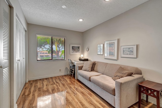 living room with light hardwood / wood-style floors and a textured ceiling