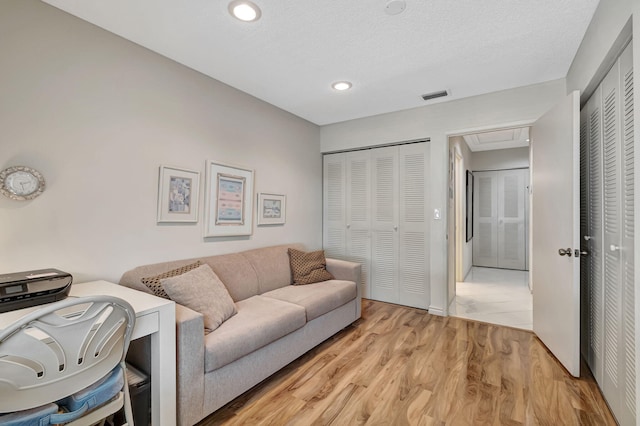 living room featuring a textured ceiling and light hardwood / wood-style flooring