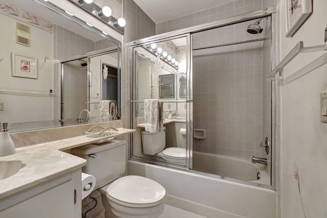 full bathroom featuring vanity, toilet, and bath / shower combo with glass door