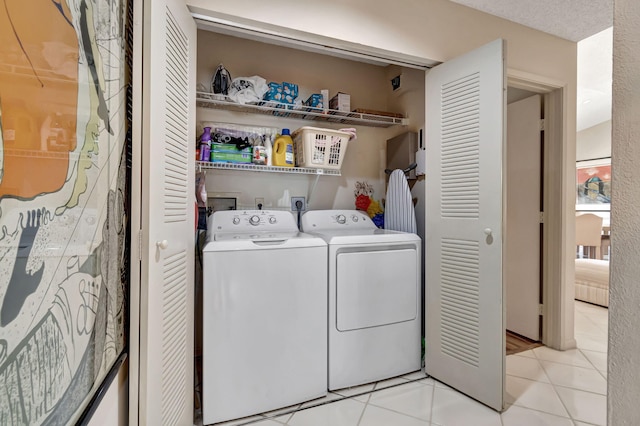 washroom featuring light tile patterned flooring and washing machine and clothes dryer