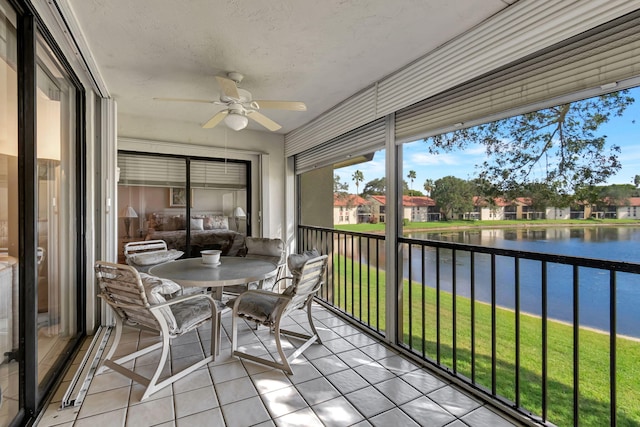 sunroom featuring a water view and ceiling fan