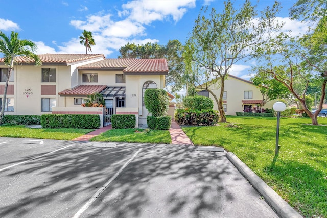 mediterranean / spanish home with a front lawn