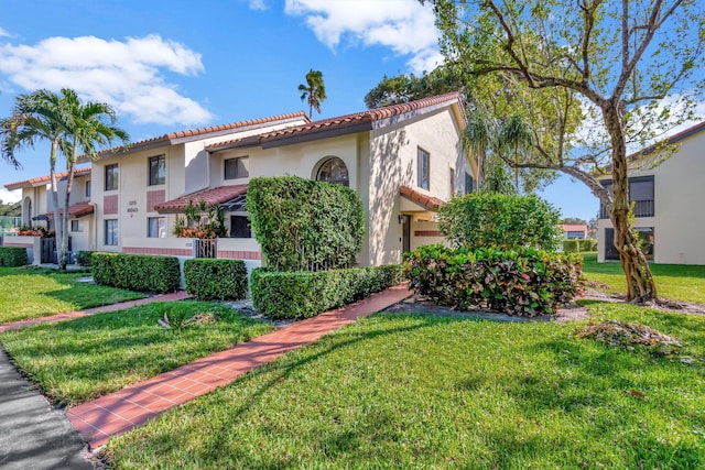 mediterranean / spanish home featuring a front lawn