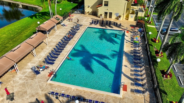 view of swimming pool featuring a patio and a water view