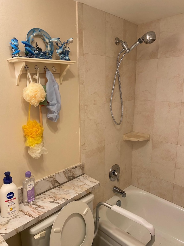 bathroom featuring tiled shower / bath and toilet