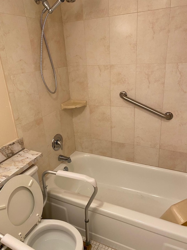 bathroom featuring tile patterned flooring, tiled shower / bath combo, and toilet