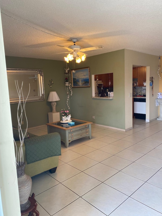 living room featuring light tile patterned flooring, ceiling fan, and a textured ceiling