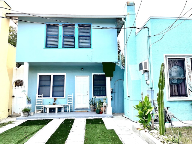 view of front of house with a wall mounted AC