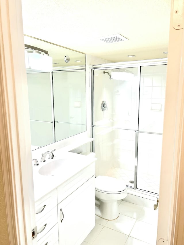 bathroom featuring tile patterned floors, vanity, toilet, and an enclosed shower