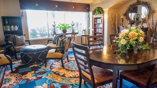 dining space featuring plenty of natural light and ornate columns