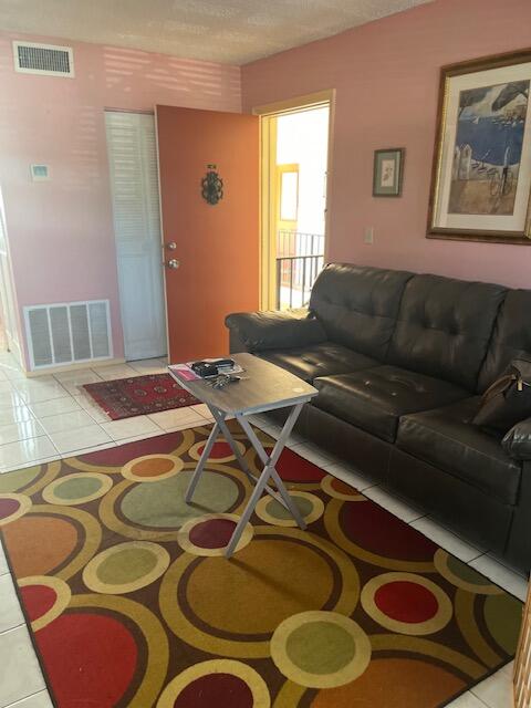 living room with a textured ceiling and light tile patterned flooring