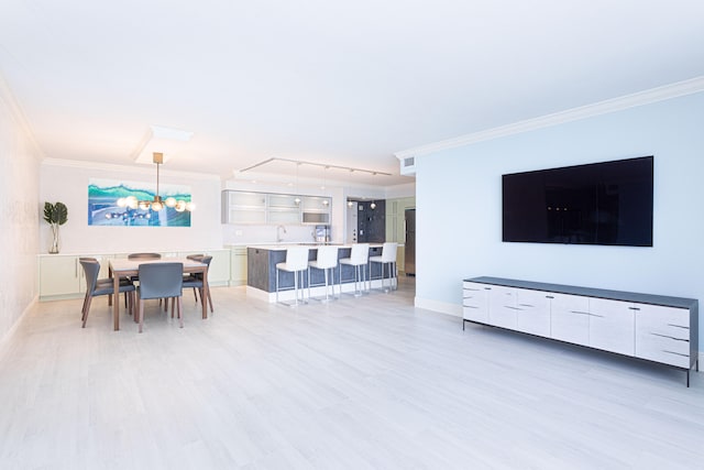 living room featuring light hardwood / wood-style flooring, crown molding, and rail lighting