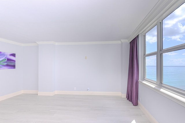 unfurnished room featuring crown molding, light hardwood / wood-style floors, and a water view