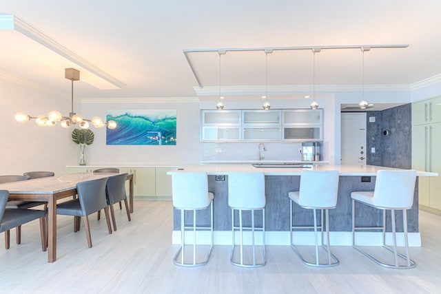 kitchen featuring a breakfast bar area, hanging light fixtures, tasteful backsplash, and crown molding