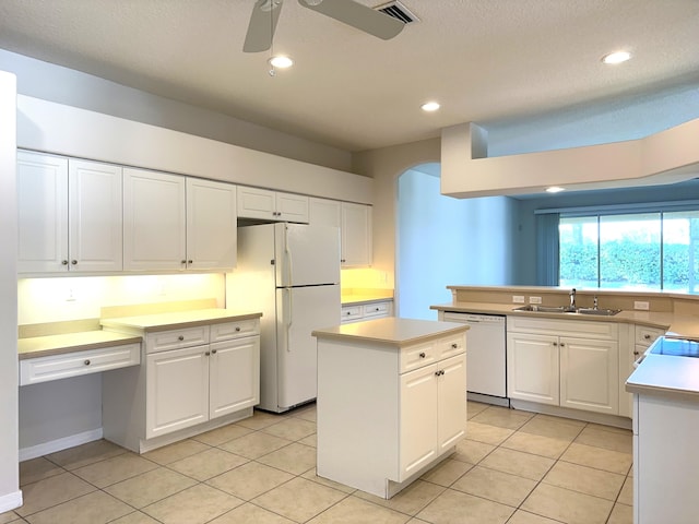 kitchen featuring ceiling fan, white cabinetry, sink, a center island, and white appliances