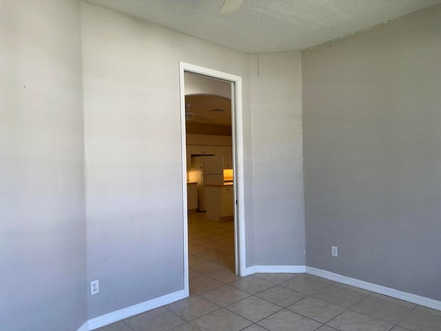 tiled spare room with a textured ceiling