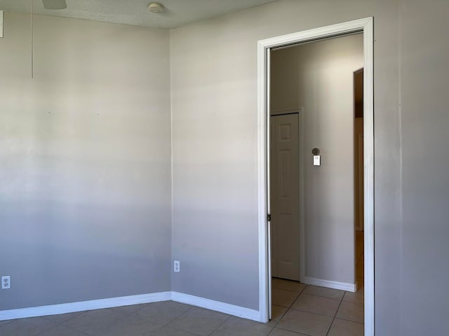 unfurnished room with a textured ceiling and light tile patterned floors