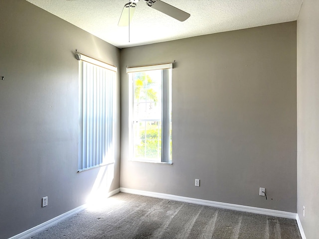 carpeted spare room with ceiling fan and a textured ceiling