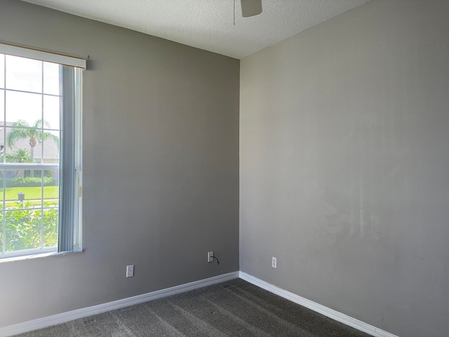 carpeted spare room featuring a textured ceiling and ceiling fan