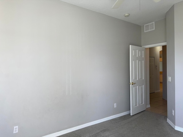 carpeted spare room featuring a textured ceiling