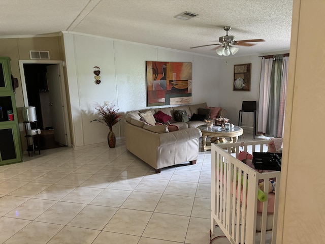 tiled living room featuring a textured ceiling, ceiling fan, lofted ceiling, and ornamental molding