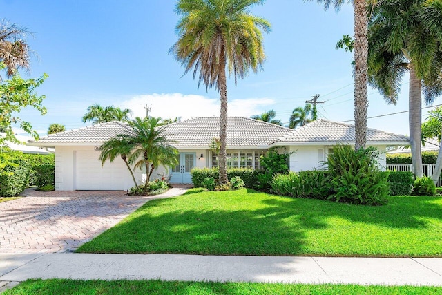 ranch-style house featuring a garage and a front lawn