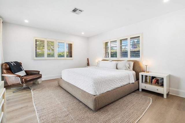 bedroom with multiple windows and light hardwood / wood-style floors