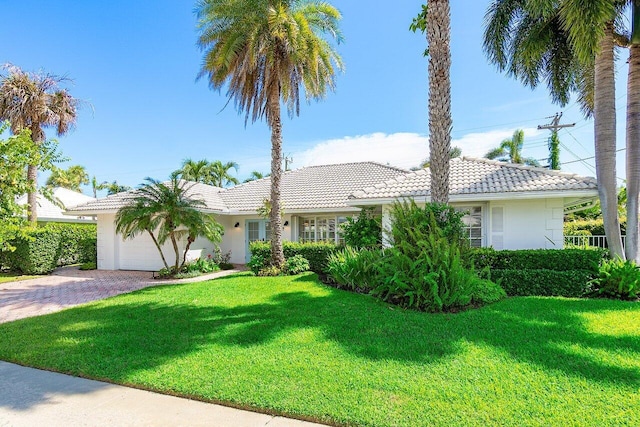 single story home featuring a garage and a front yard