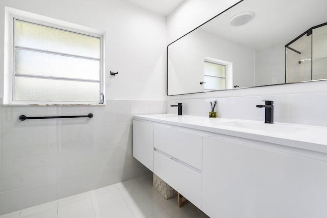 bathroom featuring vanity, a healthy amount of sunlight, tile walls, and walk in shower