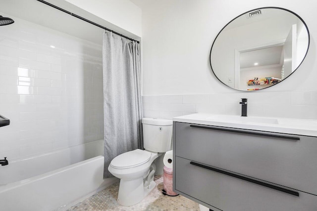 full bathroom with vanity, shower / bath combo, tile walls, and toilet