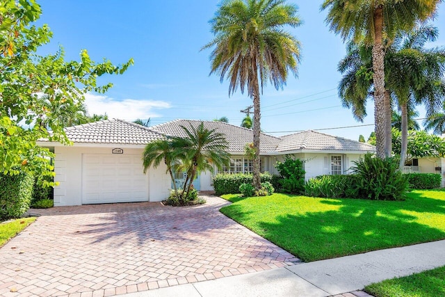 view of front of home with a front yard and a garage