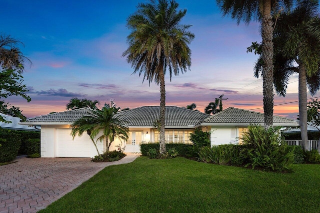 view of front of property featuring a garage and a lawn