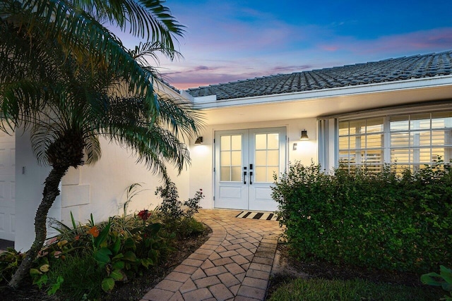 exterior entry at dusk featuring french doors