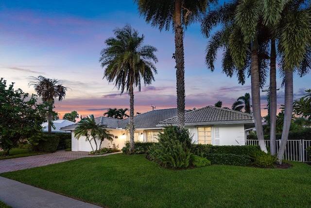 single story home featuring a yard and a garage